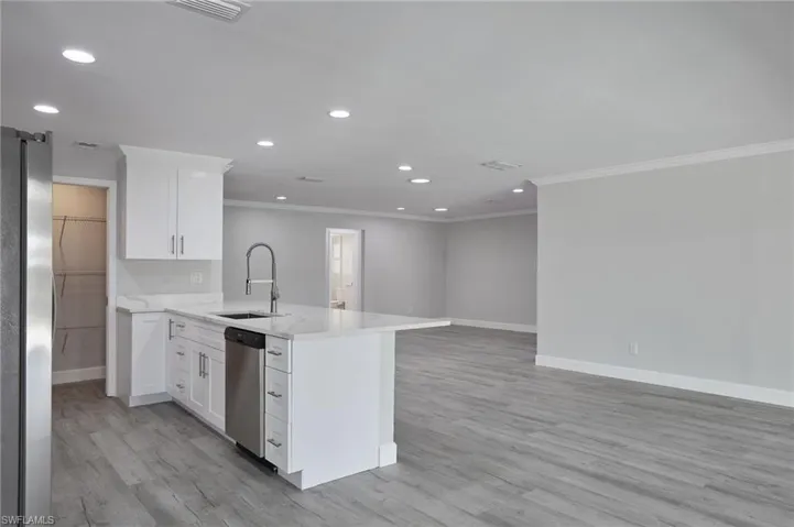 Kitchen with stainless steel appliances, a peninsula, a sink, and light wood-style floors