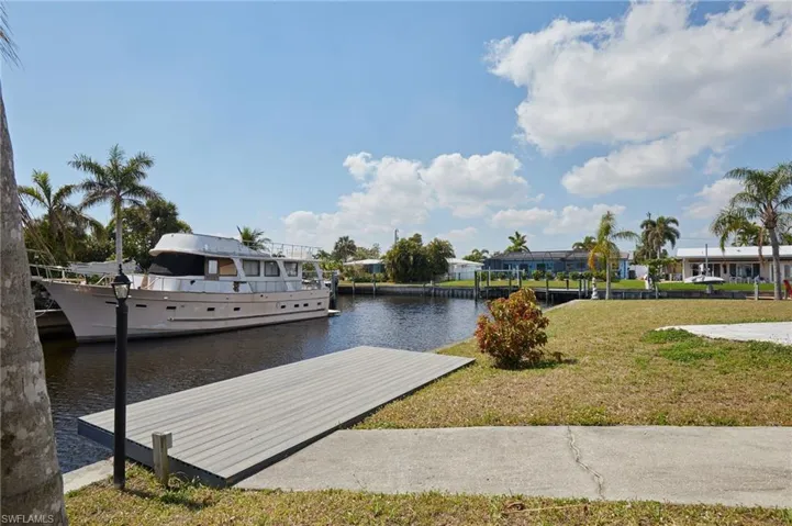 View of dock featuring a yard and a water view