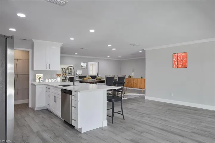 Staged Kitchen with light countertops, appliances with stainless steel finishes, a sink, a peninsula, and a kitchen breakfast bar