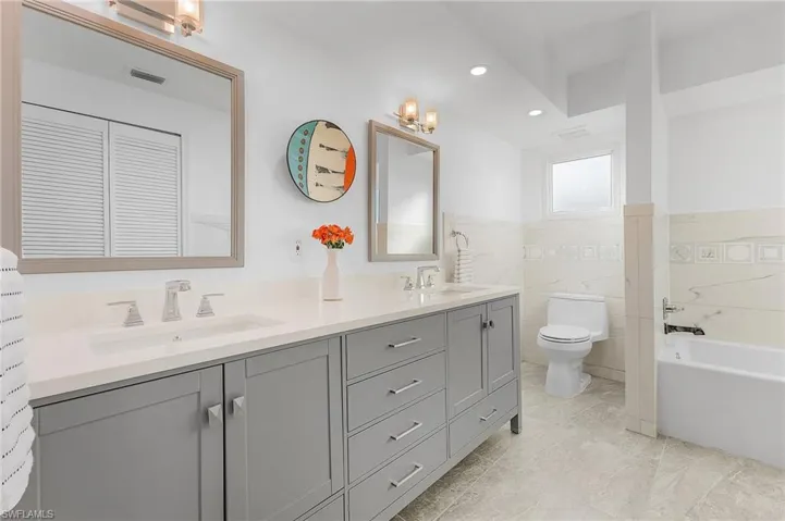 Remodeled primary with double sinks, tub and walk in shower