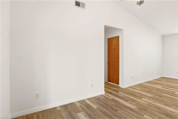 Bonus room with lofted ceiling and light wood-style flooring