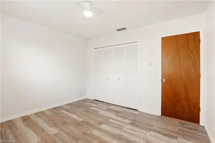Unfurnished bedroom with light wood-style floors and a closet
