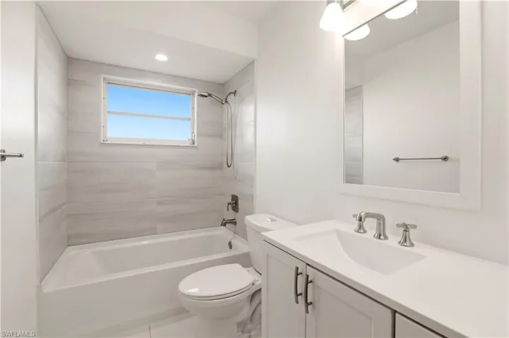 Bathroom featuring vanity, shower / bath combination, and recessed lighting