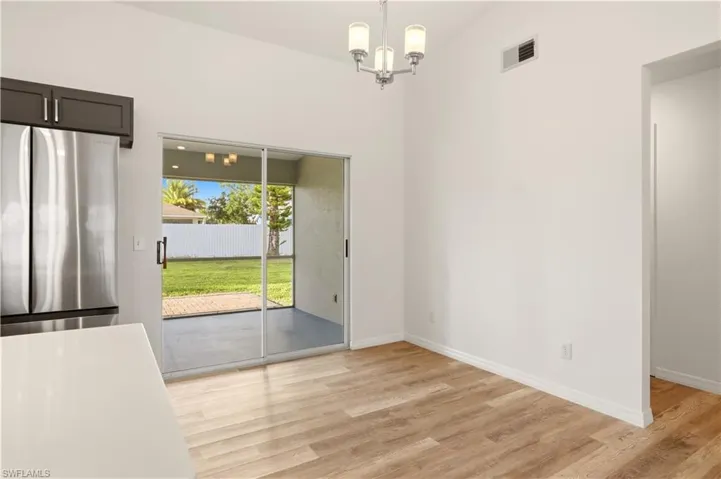 Unfurnished dining area with suspended lighting and light wood-type flooring