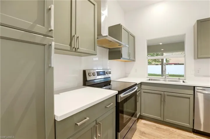Kitchen featuring stainless steel appliances, light wood finished floors, and gray cabinets