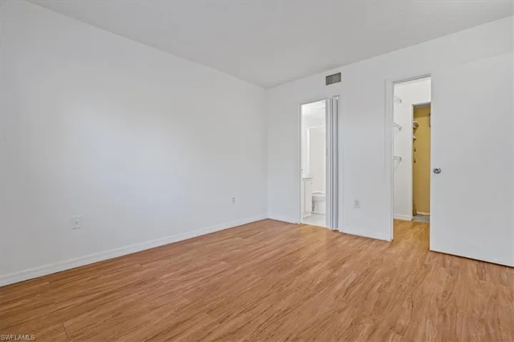 Unfurnished room featuring visible vents, baseboards, and light wood-style floors