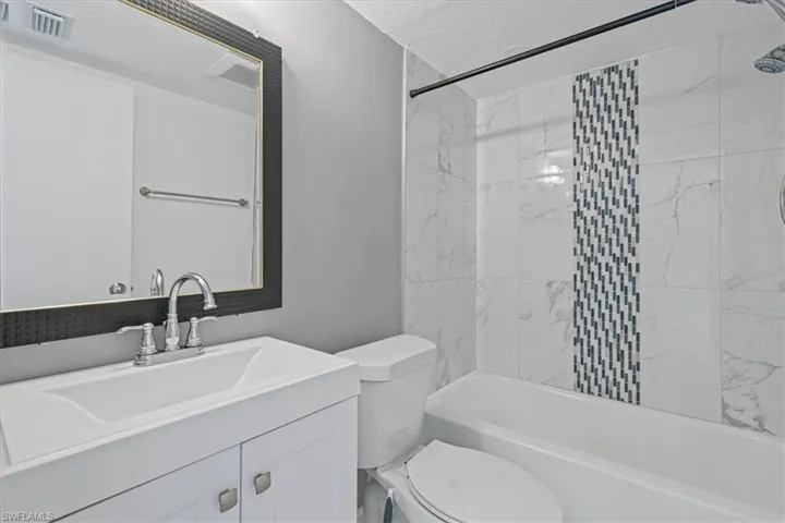 Bathroom with visible vents, shower / washtub combination, toilet, and vanity