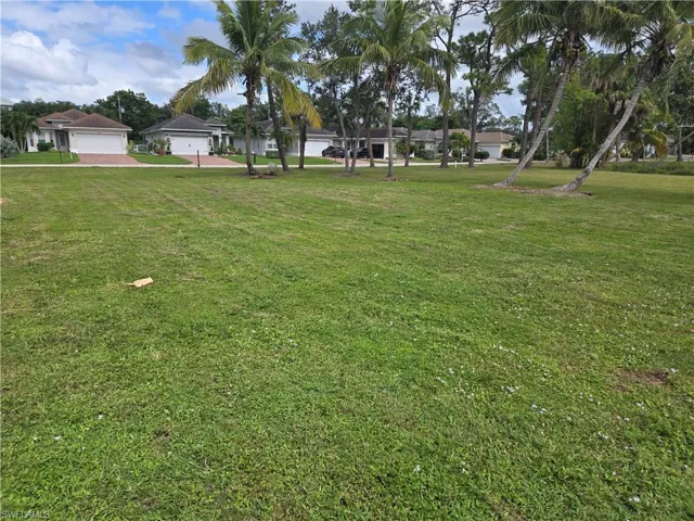 View of green lawn with a residential view