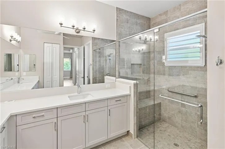 Primary Bathroom Spacious bathroom featuring a dual vanity with white countertops, light gray cabinetry, and undermount sinks