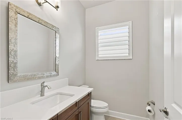 Bathroom vanity featuring a rectangular undermount sink, brushed nickel faucet, and a quartz countertop