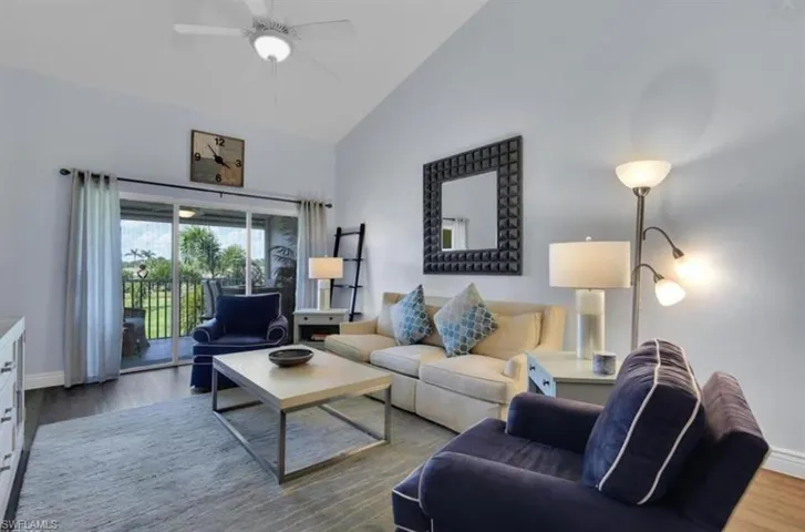 Living room featuring hardwood / wood-style floors, high vaulted ceiling, and ceiling fan