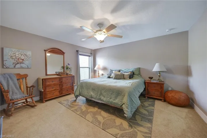Carpeted bedroom featuring ceiling fan