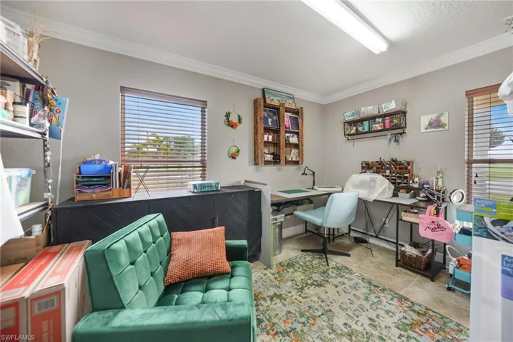 Den/Office/bedroom featuring a textured ceiling, light tile patterned flooring, and ornamental molding