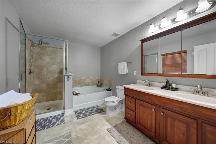 Laundry room on second level featuring a textured ceiling, washer and clothes dryer, and cabinets next to master bedroom