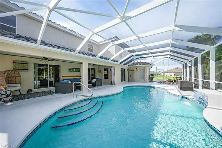 View of swimming pool with ceiling fan, a patio, a lanai, and pool water feature