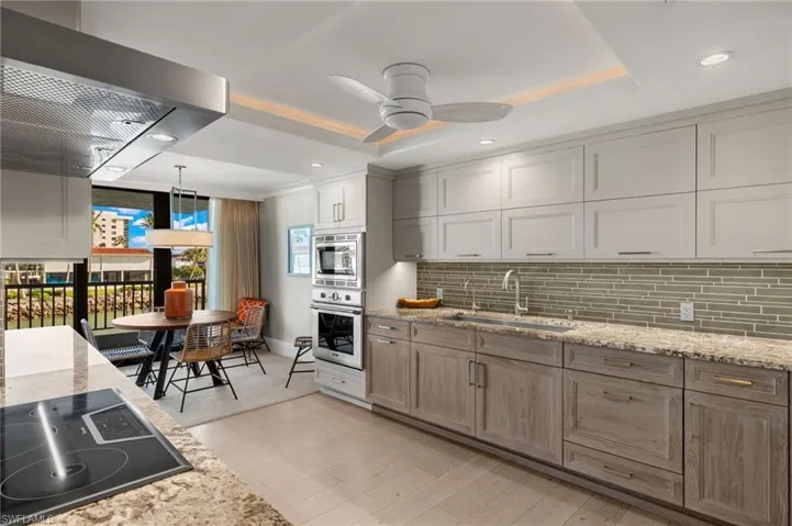 Kitchen with sink, light hardwood / wood-style flooring, oven, pendant lighting, and black electric stovetop