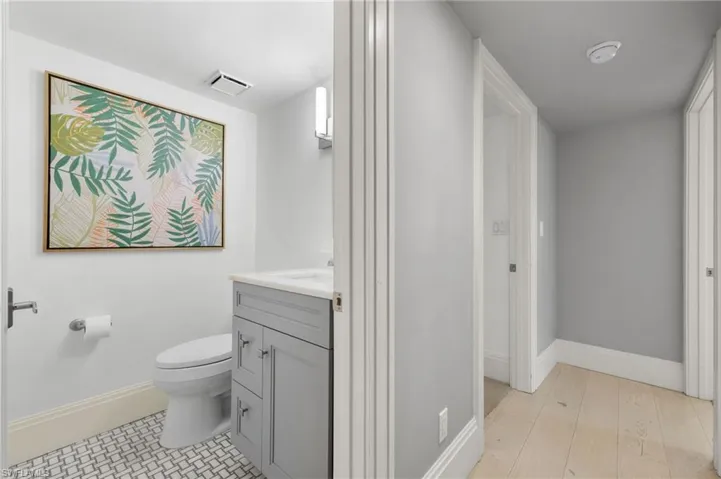 Bathroom with hardwood / wood-style floors, vanity, and toilet