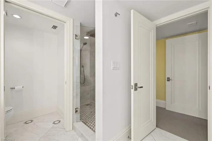 Bathroom featuring toilet and a shower with door