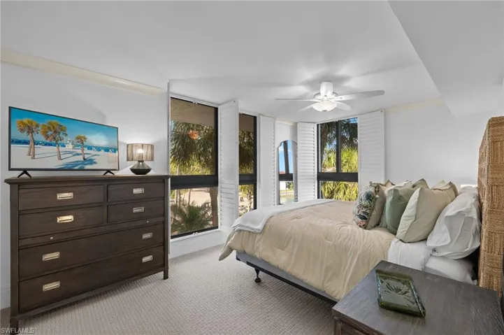 Bedroom with ceiling fan, crown molding, and light colored carpet