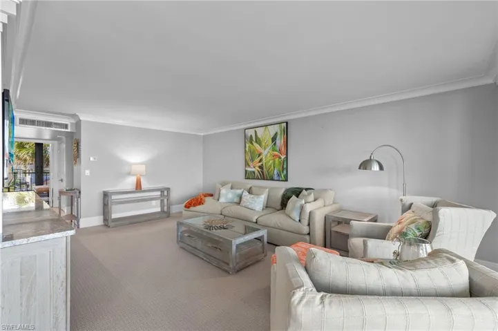Carpeted living room with ornamental molding