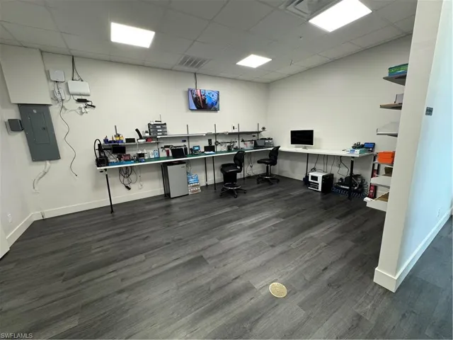Home office with a drop ceiling and electric panel
