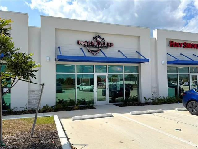 View of commercial property with uncovered parking