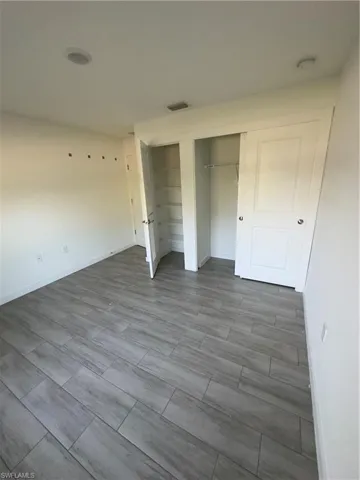 Unfurnished bedroom featuring two closets and light wood finished floors