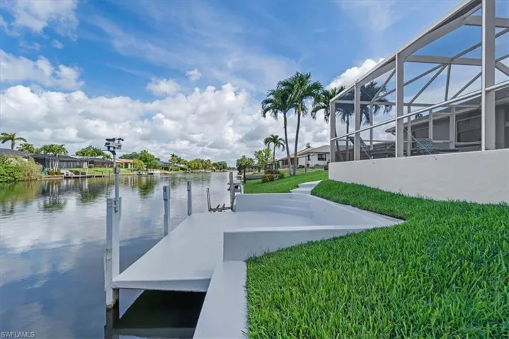 Waterside property featuring a private dock with pilings and an integrated staircase