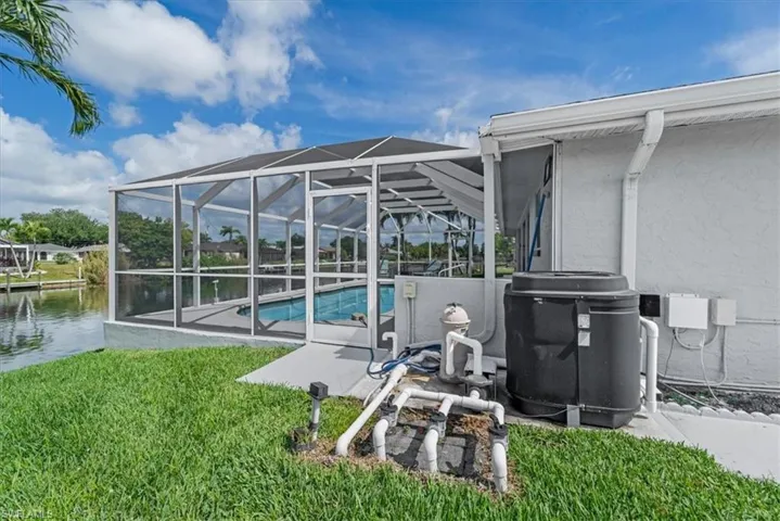 Screened pool enclosure with a concrete deck, an in-ground heated, salt water swimming pool, and a waterfront setting