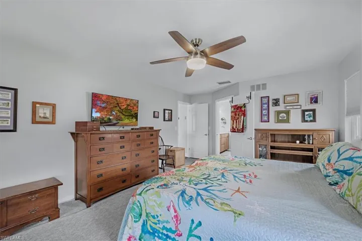 Neutral-toned bedroom featuring carpet flooring and a ceiling fan with integrated lighting