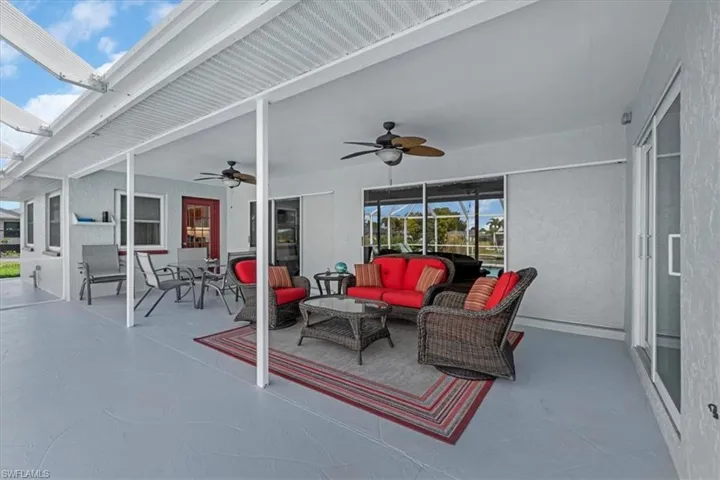 Expansive covered lanai featuring textured flooring, multiple ceiling fans, and a screened enclosure