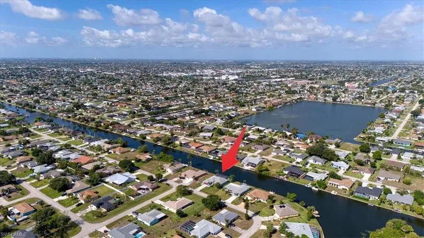 Aerial perspective showcasing a residential community with canals and a central lake