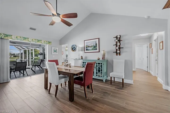 Vaulted ceiling dining area featuring wood-finish flooring and a ceiling fan