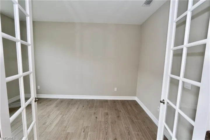 Unfurnished room with wood finished floors and baseboards