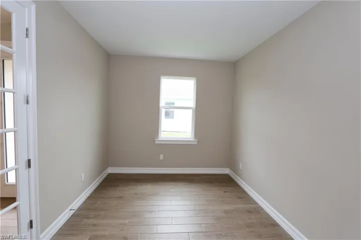 Spare room featuring wood tiled floors and baseboards