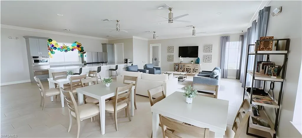 Dining space with a ceiling fan and crown molding