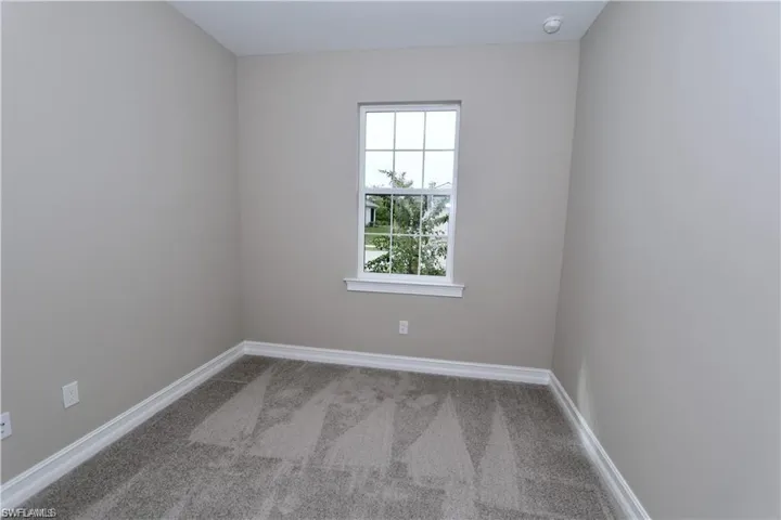 Empty room featuring light carpet and baseboards