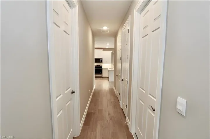 Corridor featuring wood finished floors and recessed lighting