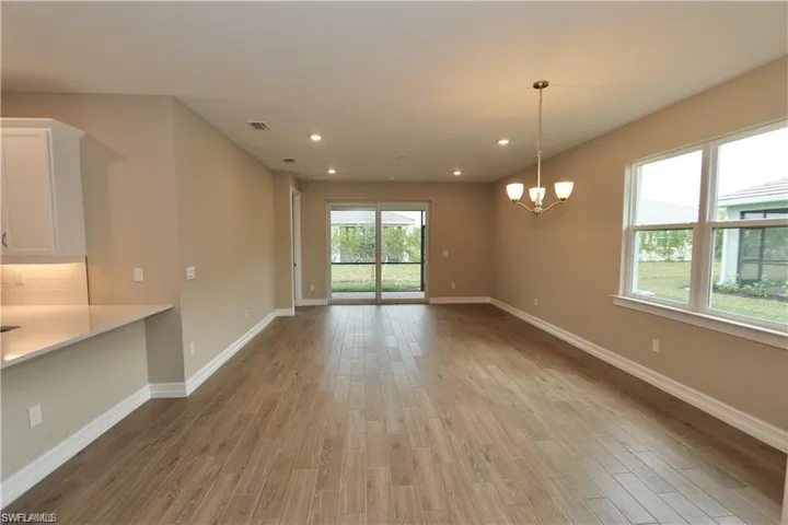 Unfurnished dining area with a chandelier, light wood-style floors, and recessed lighting