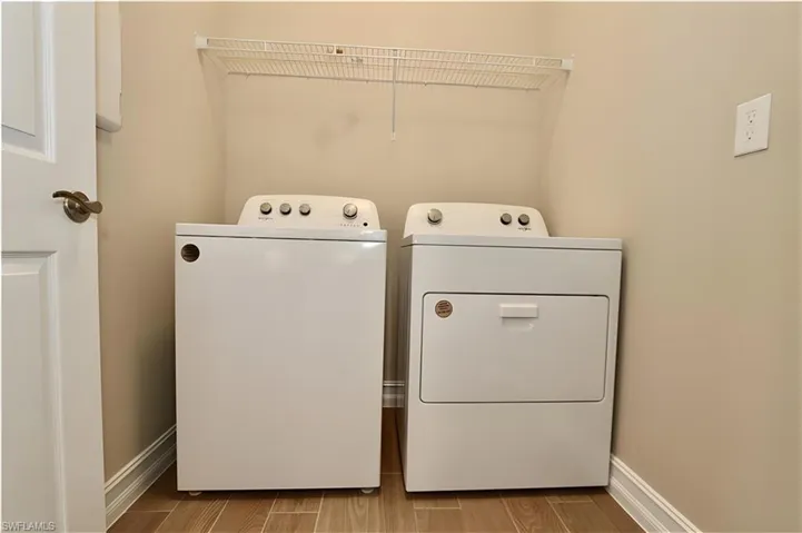 Laundry area featuring wood tiled floors and washing machine and dryer