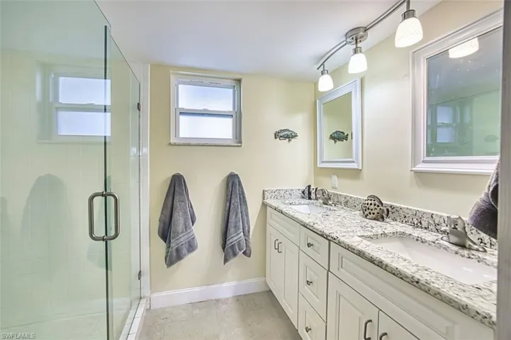 Master Bathroom featuring double vanity and a shower stall