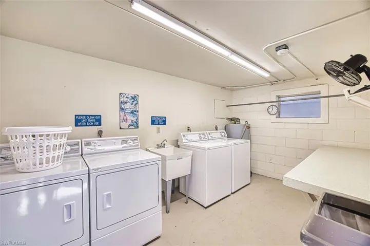 Laundry room with washing machine and dryer, concrete floors, and water heater