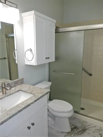 Master Bath featuring tile flooring, New Vanity, Toilet an enclosed shower
