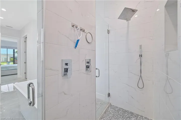 Full bath featuring a marble finish shower and recessed lighting