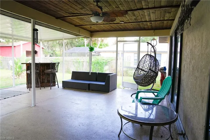 Screened-in patio featuring a wood-finish plank ceiling, ceiling fan, and concrete flooring
