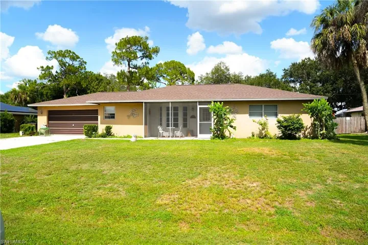 Single-story residence featuring a screened front porch, an attached garage with a horizontal panel door, a shingle roof, and a concrete driveway
