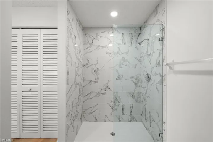 Bathroom with a tile shower and wood-type flooring