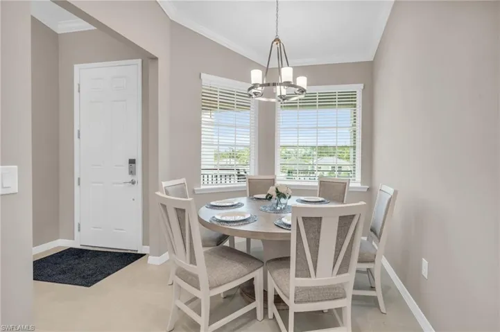 Tiled dining room with a notable chandelier and ornamental molding