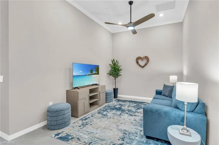Living room featuring ceiling fan and crown molding