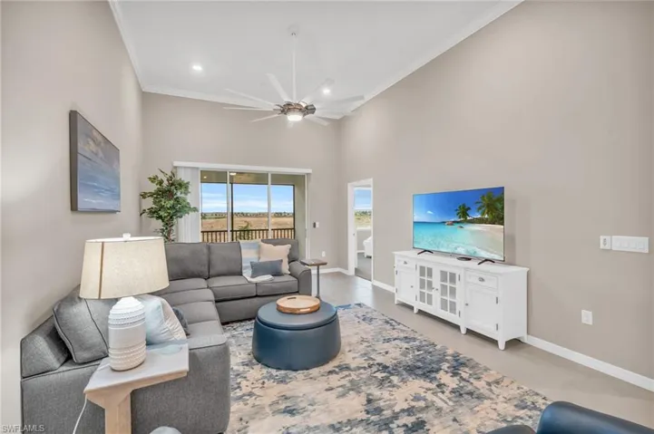 Living room with ceiling fan and ornamental molding